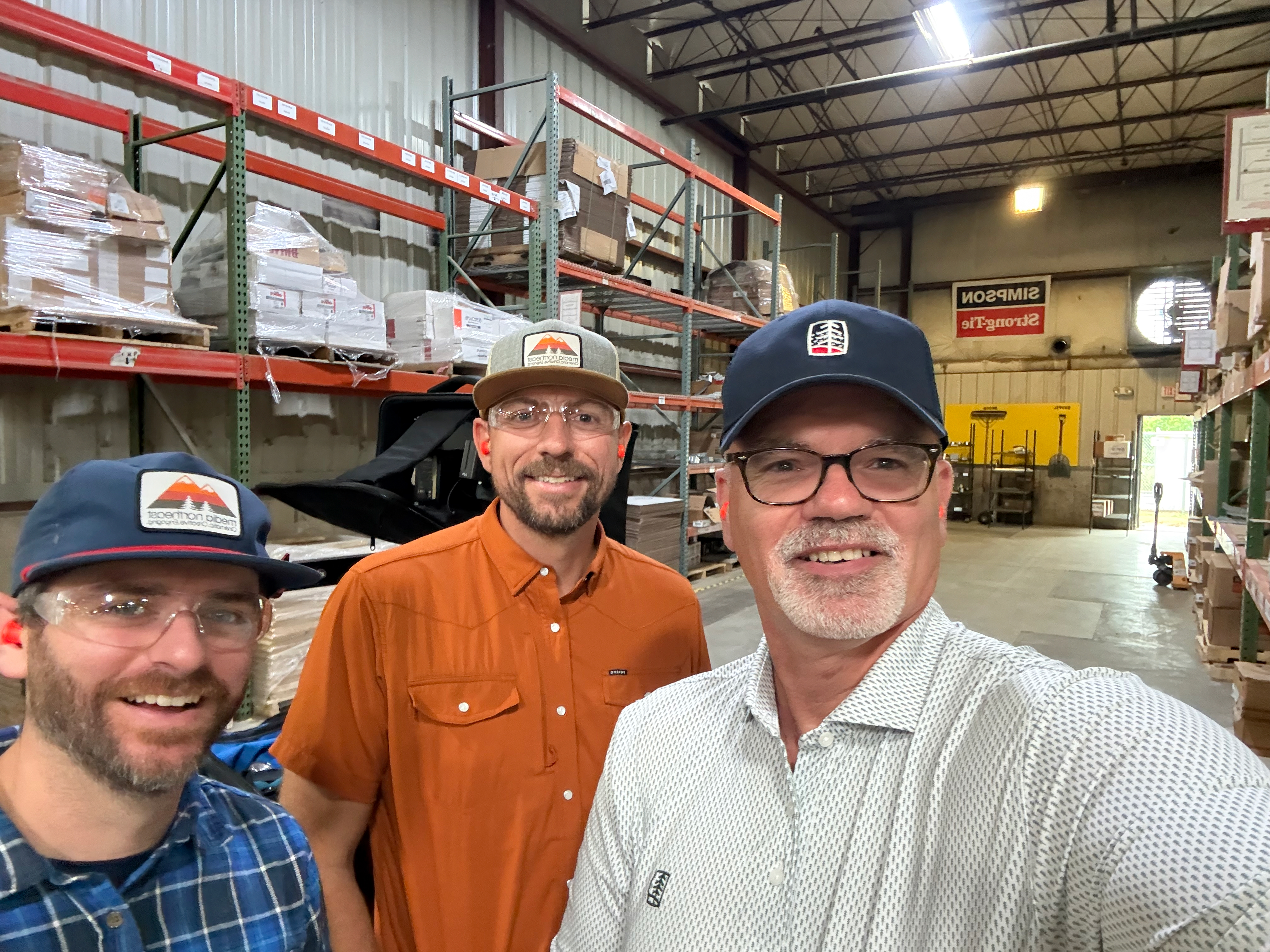 Bruce with colleagues in a lumber warehouse